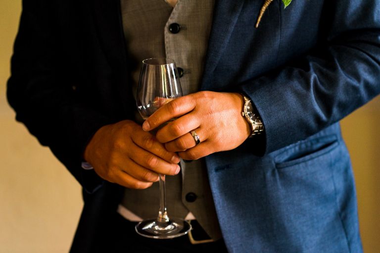 Groom's wedding ring and champagne detail shot