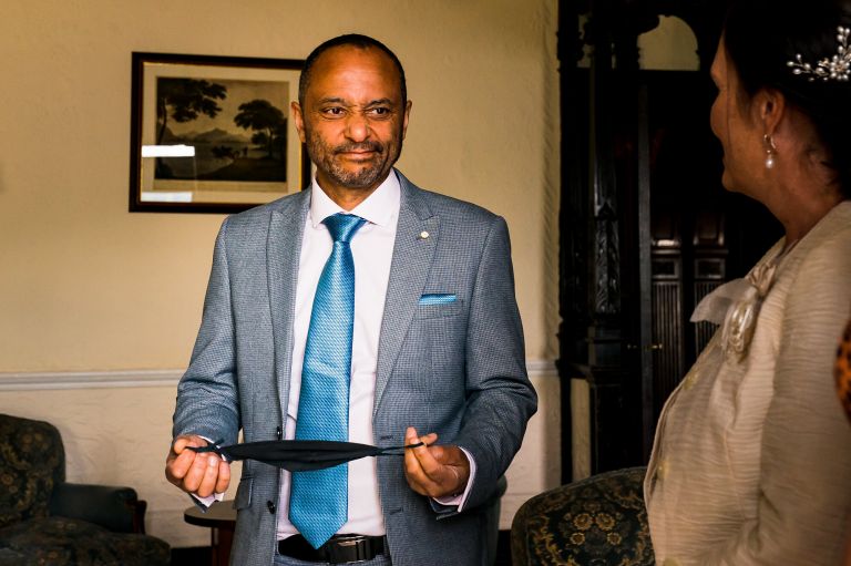 Father of the groom putting his face mask on 
