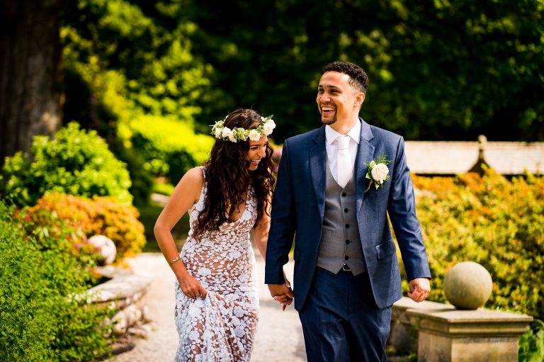 Happy moment between the bride and groom walking in the gardens of langdale chase hotel