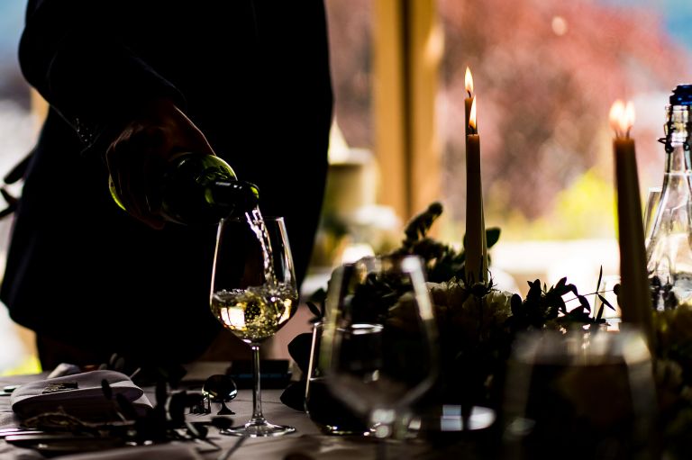 Wedding planner poring the champagne into the glass