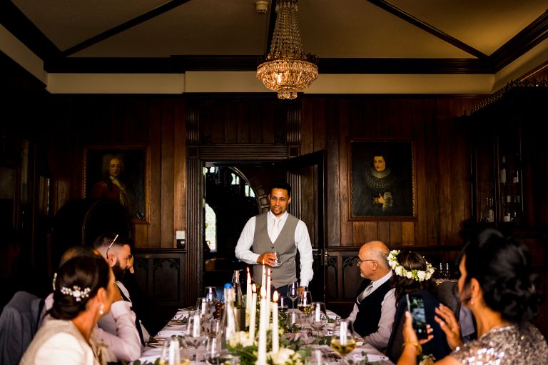 Groom is doing his speech standing in front of his intimate wedding party
